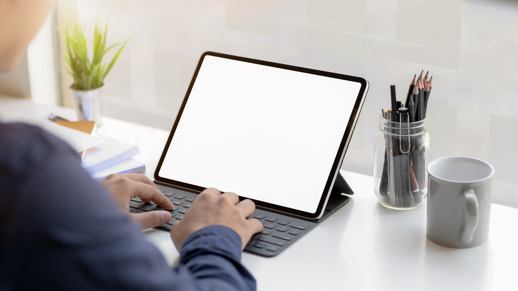 Crop man using laptop at table in office